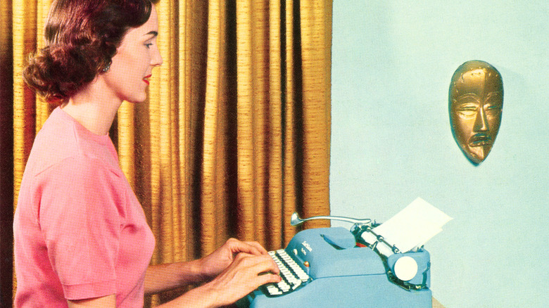 Vintage photo of a woman seated, using a typewriter