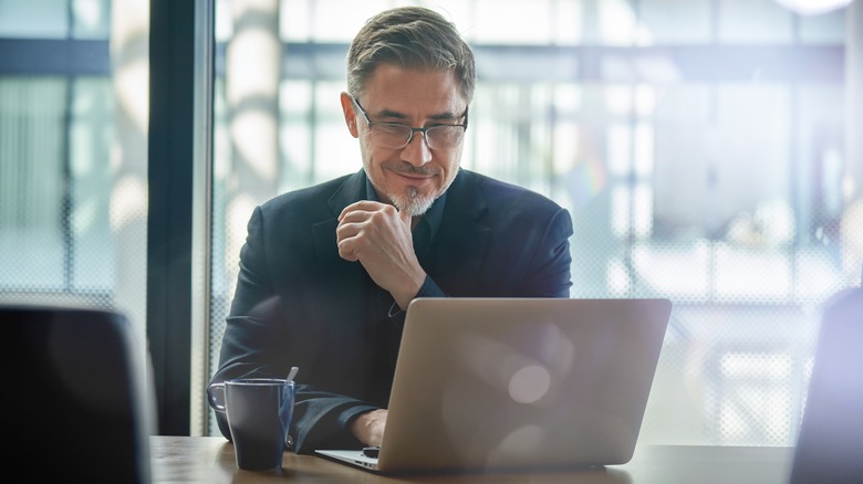 man smiling at laptop
