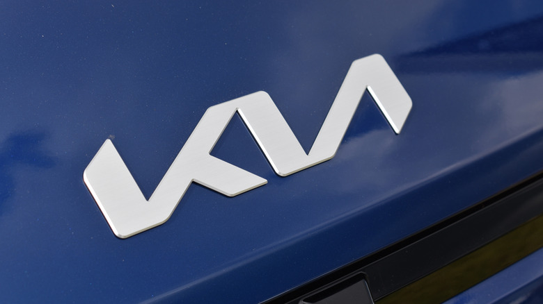 A closeup of the Kia logo on a blue car.