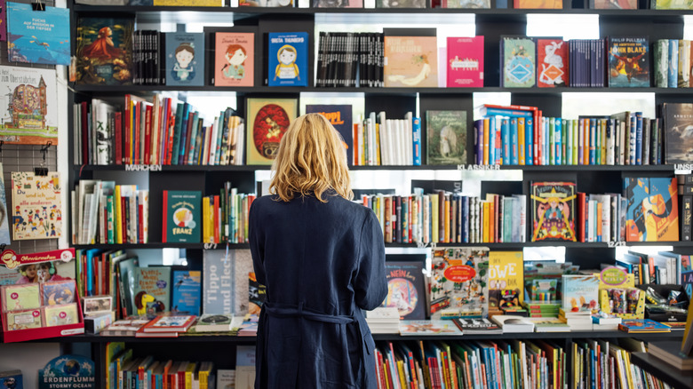 a woman looking at a book collection
