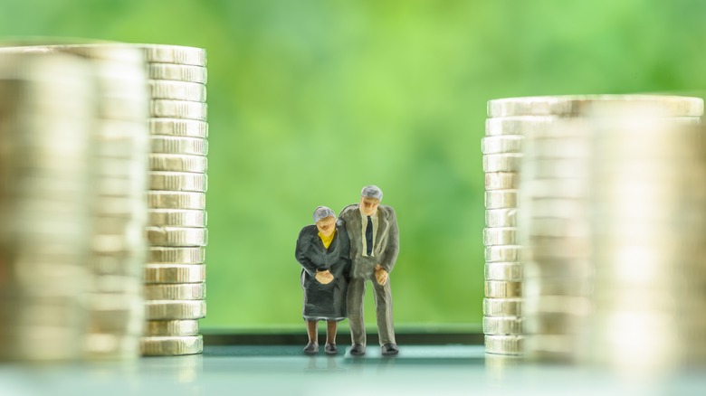 figures of older people standing between piles of money