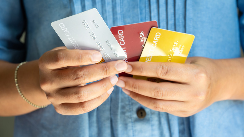 hands holding three credit cards