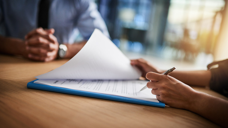 salesperson looking at papers on a clipboard