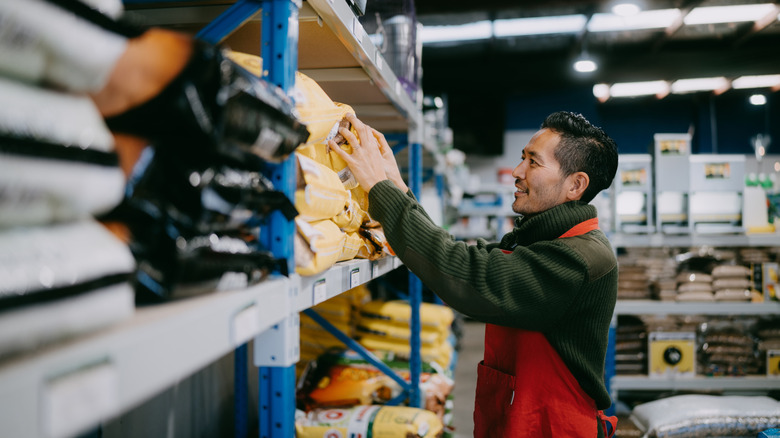 retail worker putting something on a shelf