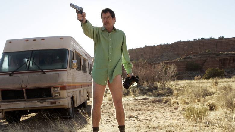 Walter White holding a weapon in front of the RV lab.