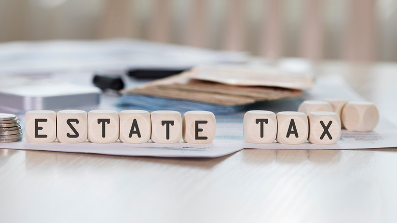 Word ESTATE TAX is composed of wooden letters.