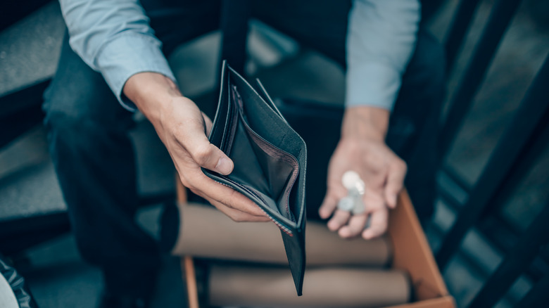 Man holding empty wallet open.