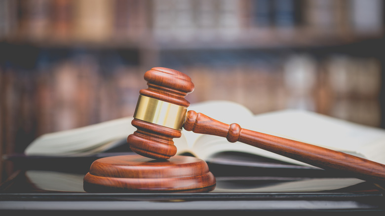Image of judge's gavel with unfocused shot of open book in background
