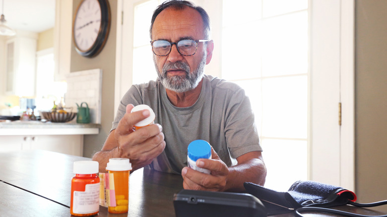 Older man checking medication bottles