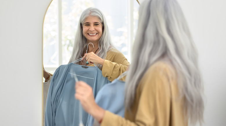 woman holding a shirt in mirror