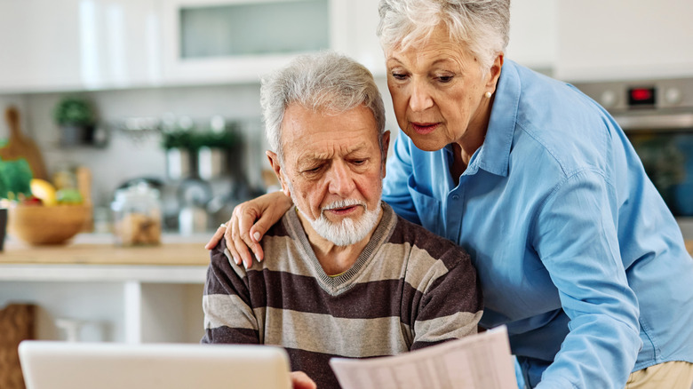 A senior couple looking over their bills
