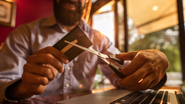 A man cutting up a credit card