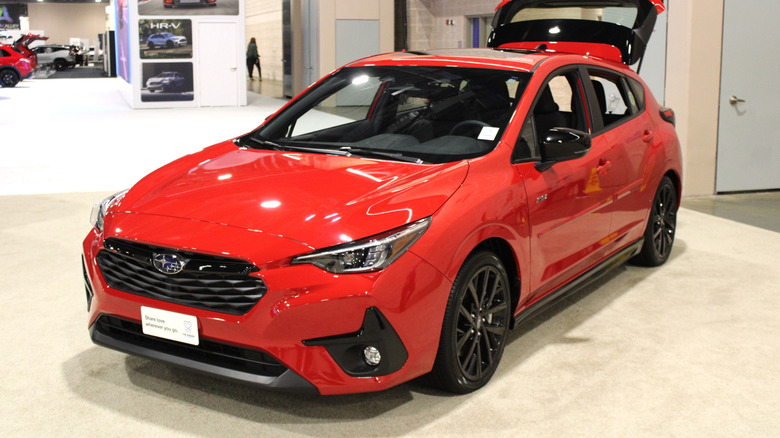 A red Subaru Impreza on display at an auto show.