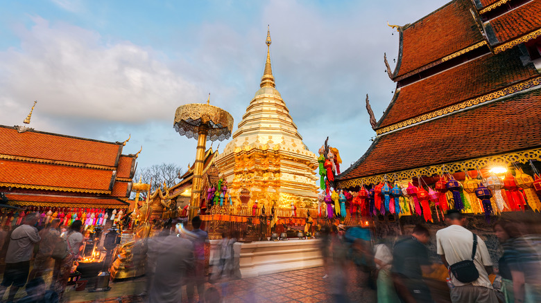 People walking around Golden temple in Chiang Mai during daytime