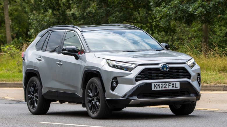 2022 silver hybrid electric TOYOTA RAV4 car driving on an English road