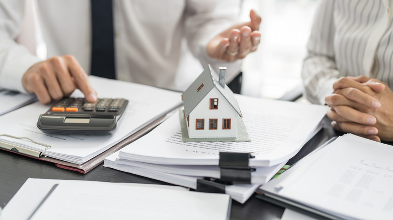 People signing contract making deal with real estate agent.
