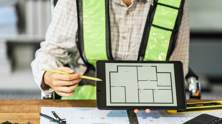 Female architect engineer is drafting blueprints adhering to building codes