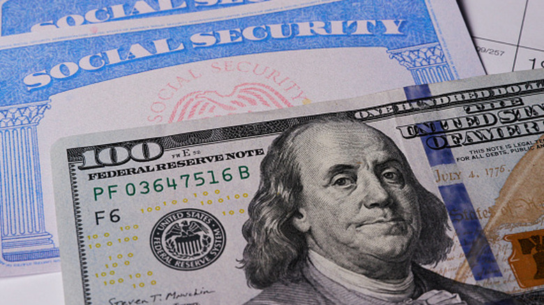 A $100 bill on top of a Social Security card.