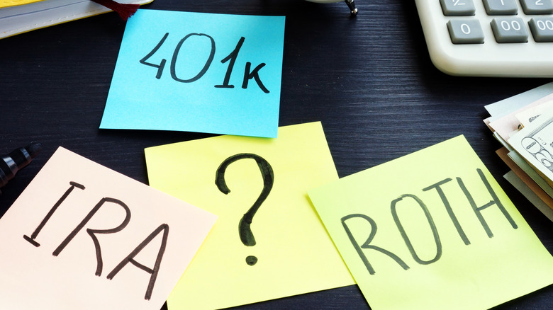 Various post-it notes with 401k, IRA, and ROTH written on them on a desk.