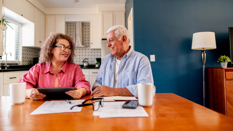 Senior couple talking at the dinner table doing home finance planning.