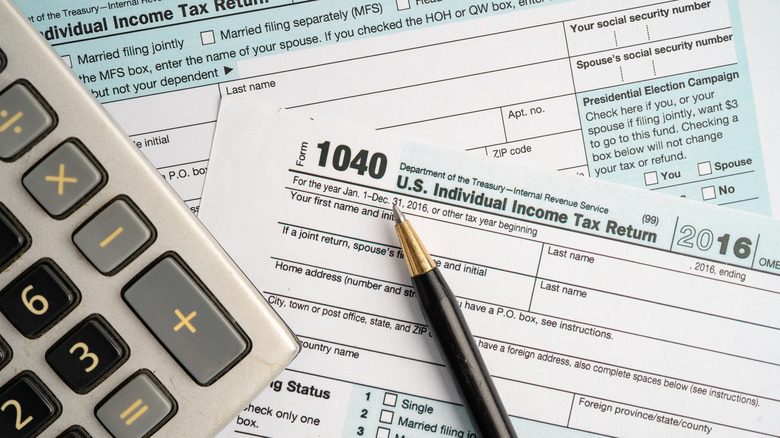 A Form 1040, U.S. Individual Income Tax Return on a table with a pen and calculator.