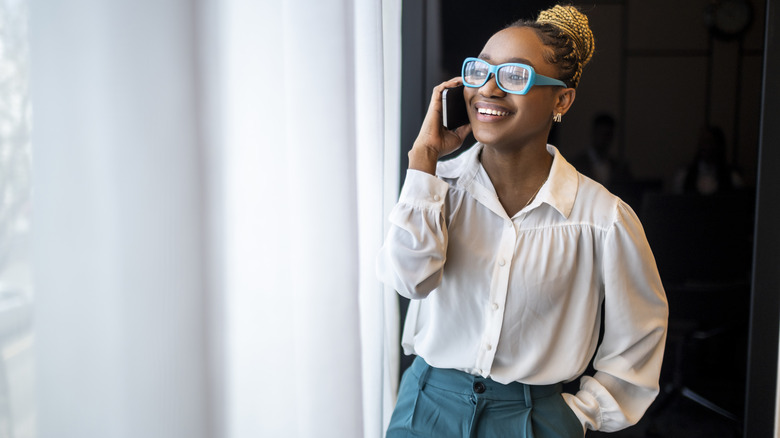 A smiling woman talking on a phone