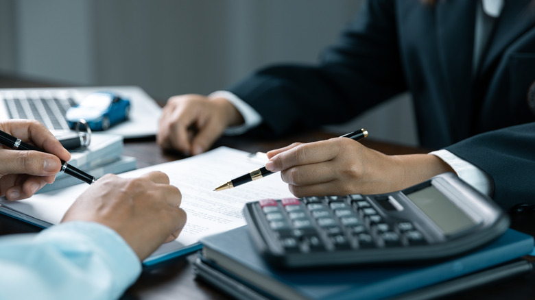 Two men holding pens over a document
