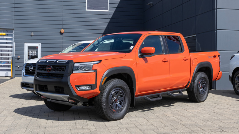 An orange Nissan Frontier on display at a dealership.