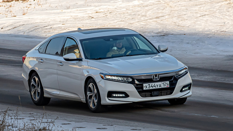 A grey Honda Accord driving on a road.