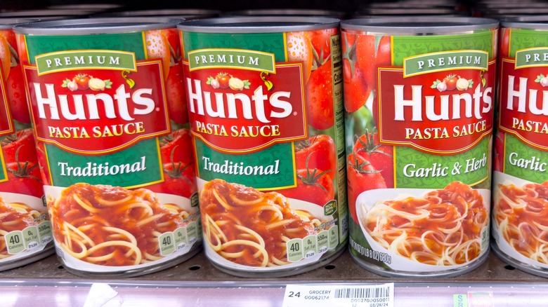 Cans of Hunt's pasta sauce on aisle shelf