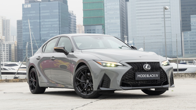 Grey Lexus IS parked with a city skyline in the background.