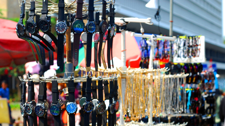 watches hanging on a street vendor's display stand