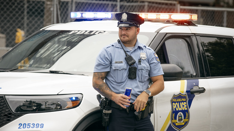 A Philadelphia PD police officer in front of a squad car in Philadelphia