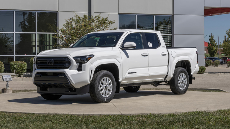 A white Toyota Tacoma on display at a dealership.