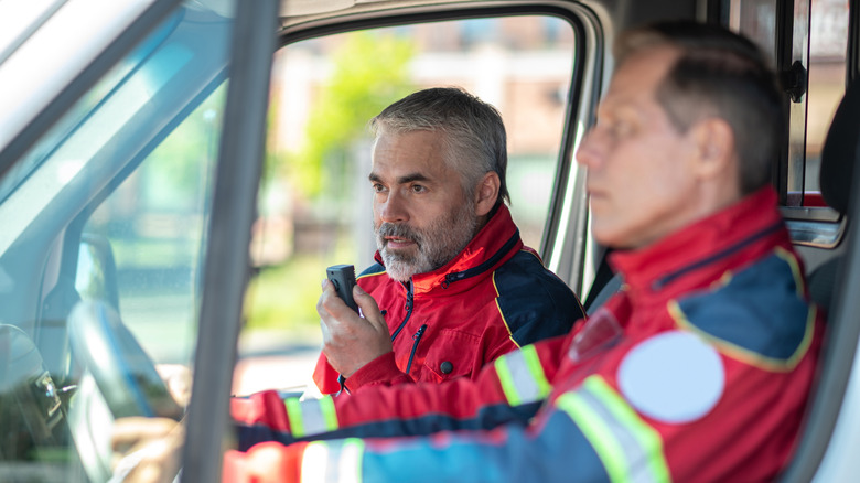 Paramedical personnel riding in an ambulance car.