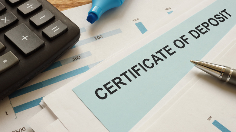 Certificate of Deposit (CDs) on paper with pen.