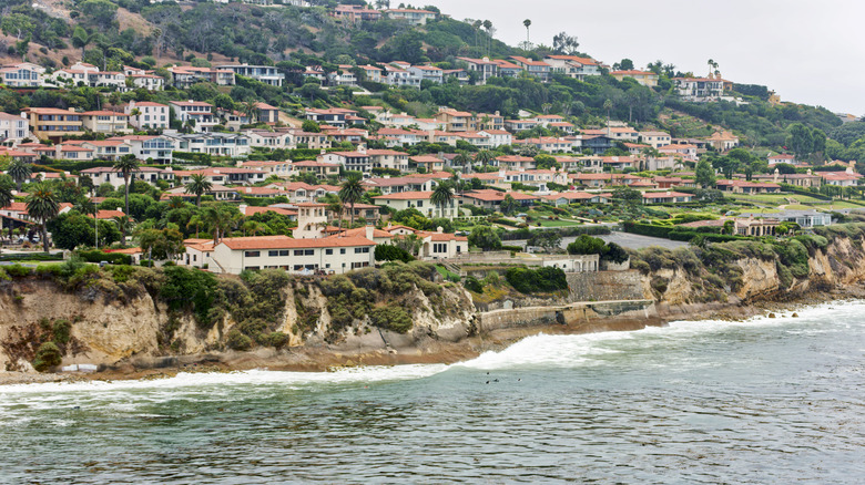 Aerial view of houses on cliff with waves splashing on coastline, Rancho Palos Verdes,