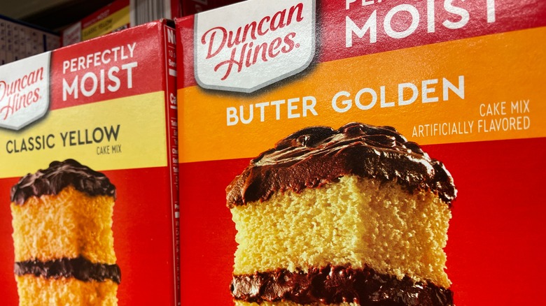 A couple of boxes of Duncan Hines Perfectly Moist cake mix on the store shelf