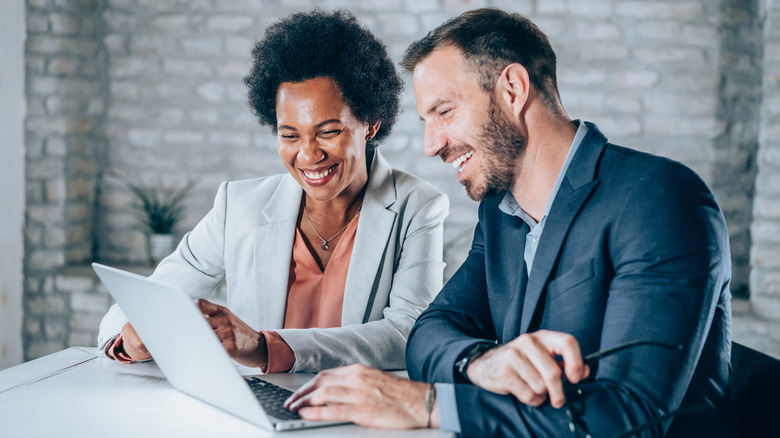 A smiling couple with a laptop