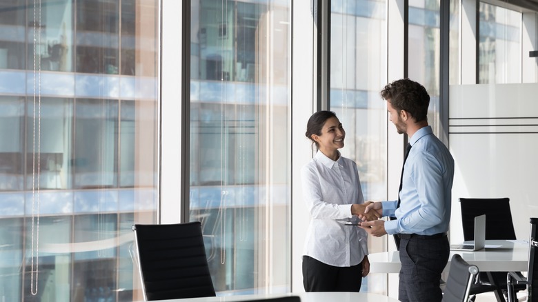 Two office workers shaking hands