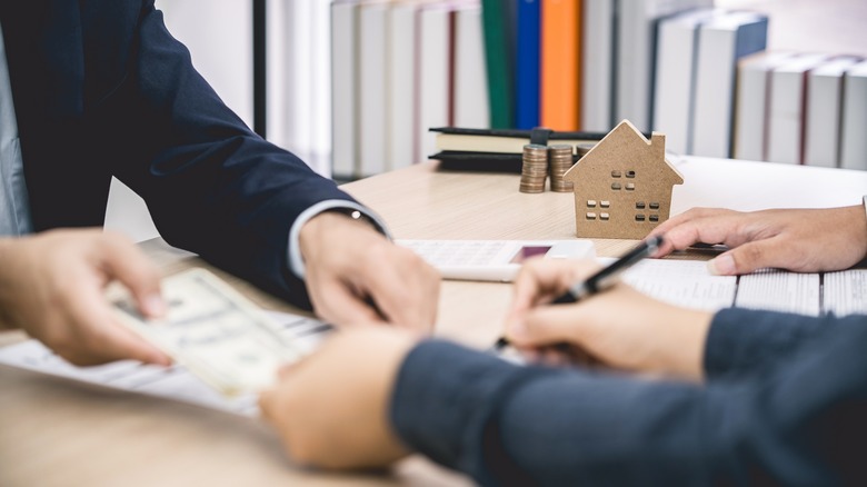 A hand signing a document