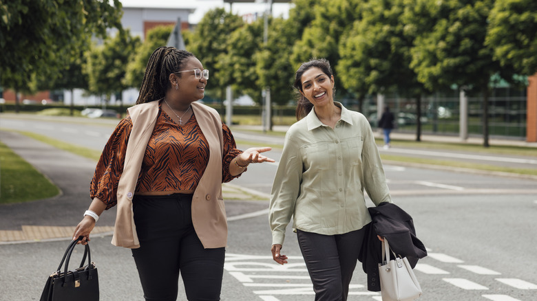 Two smiling women walking to work