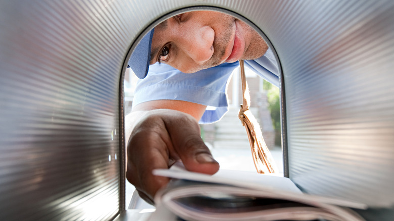man removing mail from a mailbox