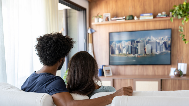A couple on a sofa watching TV