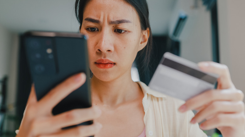 A concerned woman looking at her phone