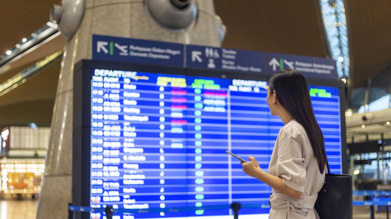 A woman looking at a departure sign