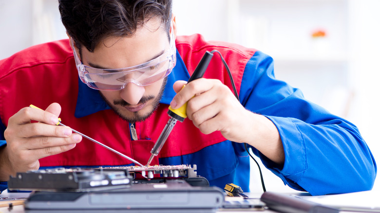 A man repairing a laptop