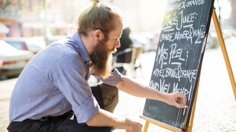 A man writing on a chalkboard