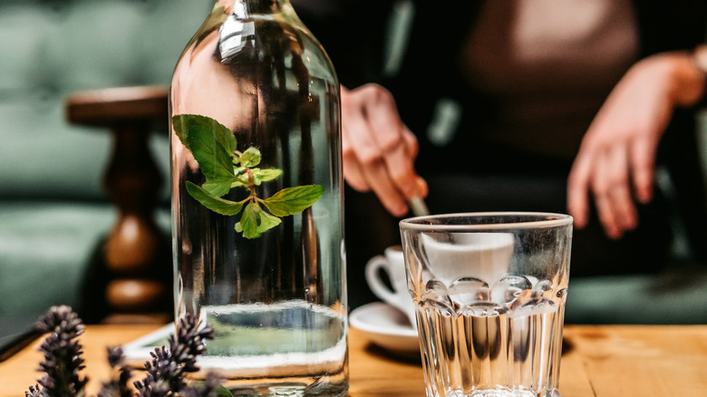 Person eating behind glass bottle of water