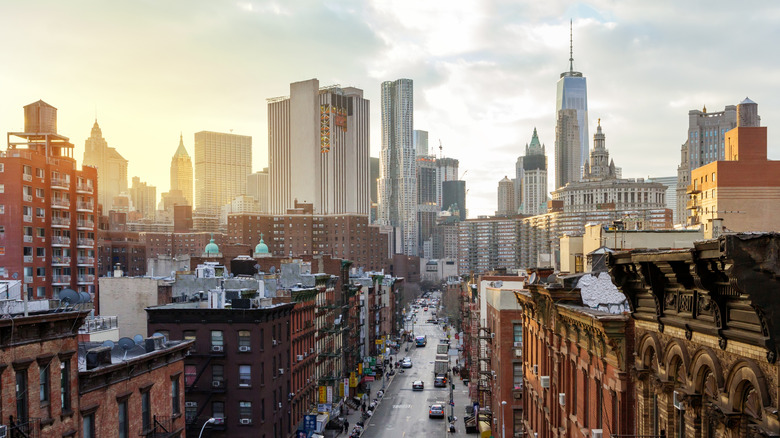 Overhead view of Madison Street in the Chinatown neighborhood of Manhattan with the downtown skyline buildings of New York City in the background.